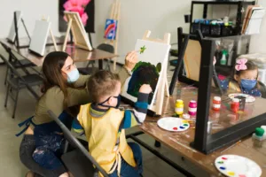 Happy young children engaging in a cooperative early literacy circle activity inside a bright, modern learn & play preschool classroom setup.