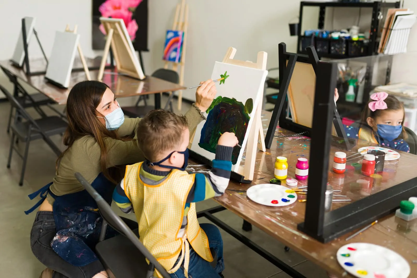 Happy young children engaging in a cooperative early literacy circle activity inside a bright, modern learn & play preschool classroom setup.